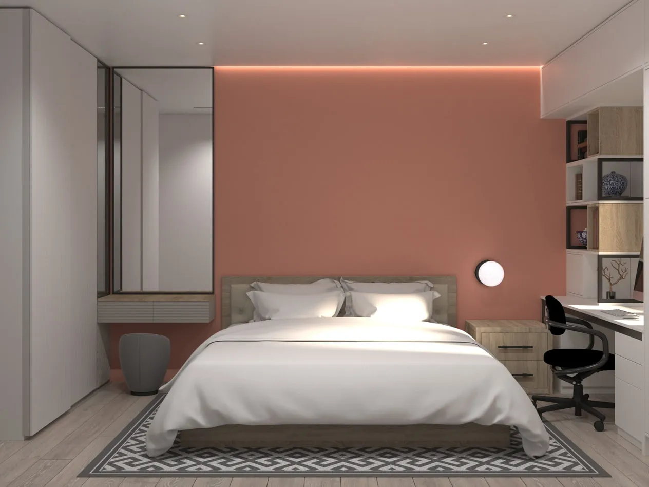 3D interior visualisation of a bedroom with a terracotta-peach accent wall and cove lighting, a double bed on a geometric rug, a full-height mirror over a floating vanity shelf and a built-in desk.